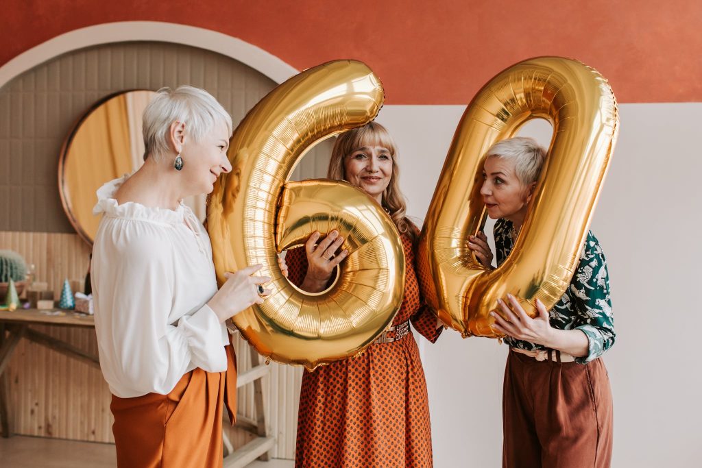 Elderly Women Holding Gold Balloons
